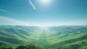 Expansive Panoramic View of Lush Green Valley and Rolling Hills Under a Bright Blue Sky. photo