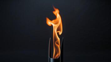 Flaming torch with orange flames on black background photo