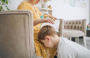 mother consoling her son during a study session at home, nurturing and supportive parenting, concept of mental health in education. Tyrant concept. photo