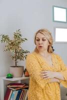 concerned mother standing in a home study area, expressing worry or contemplation, concept of parenting and home education photo