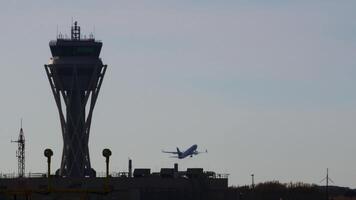 Aircraft ascending from runway against airport control tower, clear sky backdrop highlighting aviation infrastructure and travel dynamics video
