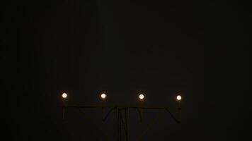 Nighttime aircraft descending toward runway, navigating with precision approach lighting system, guiding touchdown sequence against dark evening sky video