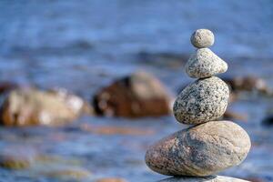Pyramid of stones. Unstable balance of stone objects. Symbol of the balance of forces in the world. photo