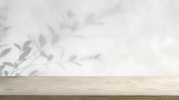 Empty wooden table with shadow of leaves on white wall photo