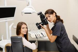 Dentist woman photographing with professional camera the result of her work in clinic. photo