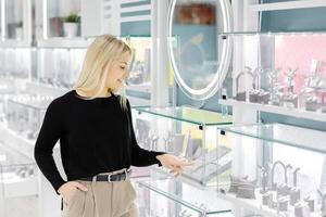 Woman choosing jewelry in a store pointing at glass display photo