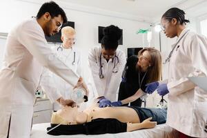 Doctors practicing cardiopulmonary resuscitation and intravenous injection on medical manikin. photo