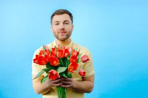 Man is holding bunch of red flowers. photo