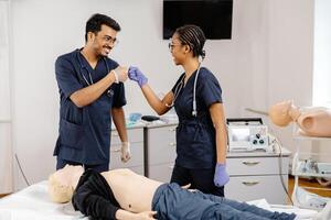 Medical Students Practicing CPR Training with Defibrillator and Mannequin photo