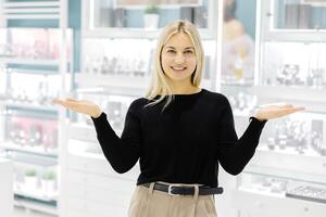 Smiling shop assistant showing jewelry in a jewelry store photo