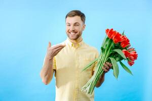 Man is holding bouquet of red tulips. photo
