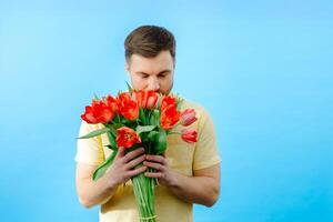 Man is holding bouquet of red tulips photo