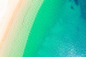 serene beach landscape with gentle waves and soft sand, top down view photography by drone photo