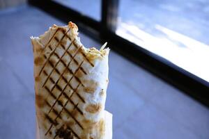 A Delicious Grilled Burrito Featuring a Bite That Has Been Taken Out for Enjoyment photo