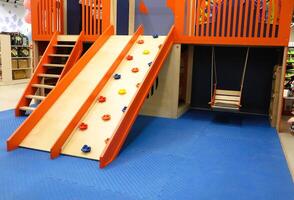 Bright, fun playground equipment with an exciting slide and a challenging climbing wall photo