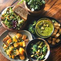 A table with a bowl of food, a bowl of soup, and a bowl of salad photo
