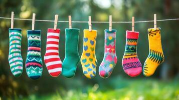 Socks hanging on clothes line in front of green trees photo
