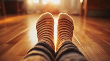 A person wearing striped socks on a wooden floor photo