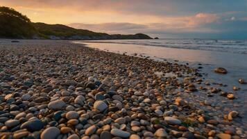 A serene beach scene with smooth pebbles and gentle waves under a colorful sunset. photo