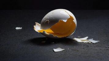 A cracked eggshell revealing a bright yolk inside. photo