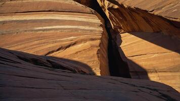 A close-up view of layered rock formations in a canyon, highlighting natural textures and shadows. photo