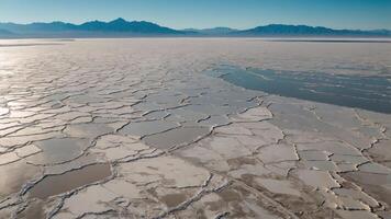 Aerial view of a vast salt flat with cracked patterns and distant mountains. photo