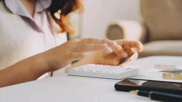 A woman is using a calculator to calculate her expenses video
