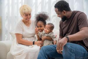 Family enjoying a cozy moment together at home with children playing and smiling during a sunny afternoon photo