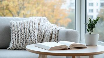 cozy corner with soft throw, open book, and plant inviting relaxation photo