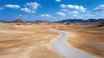 Winding road through vast desert landscape under blue sky photo