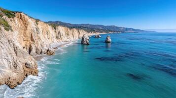 Stunning coastline with rugged cliffs and clear blue waters under bright sky photo