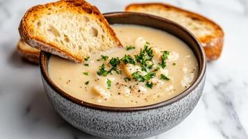 A bowl of soup with bread and parsley photo