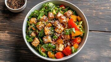 A bowl of salad with tofu, peppers and tomatoes photo