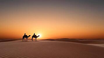 Two people riding camels in the desert at sunset photo