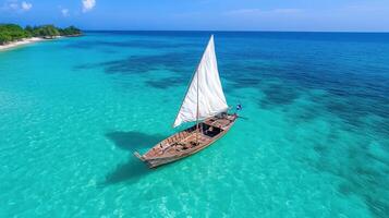 A sailboat floating in the ocean near a beach photo