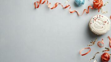 A cake with frosting and streamers on a gray background photo