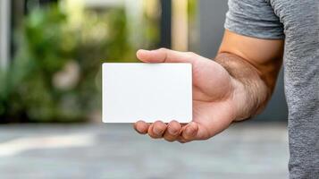 Man holding blank white card in front of green background photo