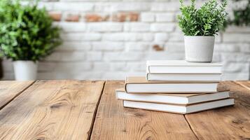 Stack of books on wooden table with white brick wall photo