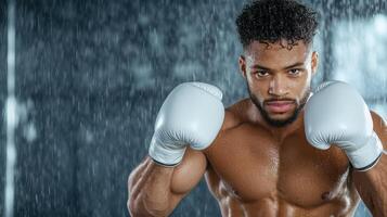 A man in boxing gloves standing in the rain photo