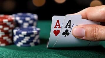 A hand holding a pair of aces and a pair of chips photo