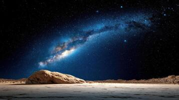 The milky way over a desert with rocks and sand photo