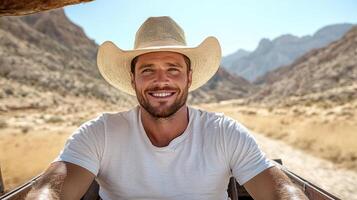A man wearing a cowboy hat smiles while sitting in a car photo