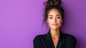 A woman in a black suit posing against a purple background photo
