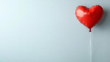 A red heart shaped balloon is hanging from a string photo