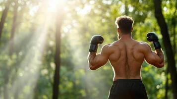 A man with boxing gloves on his back in the woods photo