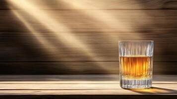 A glass of whiskey on a wooden table photo