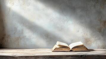 open book resting on dusty table, illuminated by soft light photo