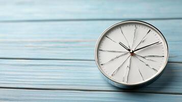 A clock on a blue wooden table photo