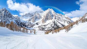 rainbow arching over snowy mountain peak creates stunning winter landscape photo