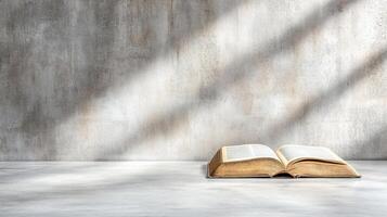 An open bible on a table in front of a wall photo